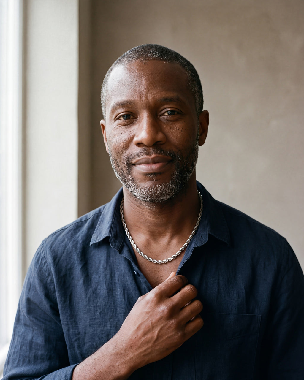 Man in a navy linen shirt by a window wearing the silver Atlas spiral rope chain