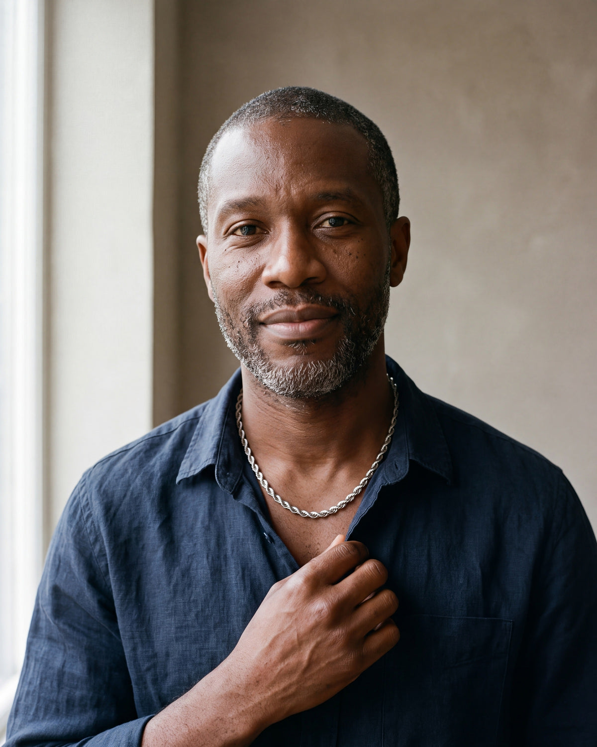 Man in a navy linen shirt by a window wearing the silver Atlas spiral rope chain
