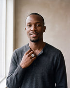 Man in a charcoal knit henley wearing the Atlas square top ring in silver-tone steel