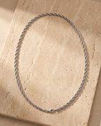 The whole silver-tone Atlas Twisted Rope Chain lying on warm travertine stone