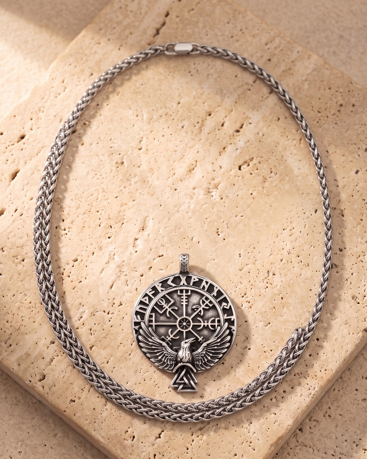 The whole Atlas raven Vegvisir compass necklace on warm stone, wheat chain