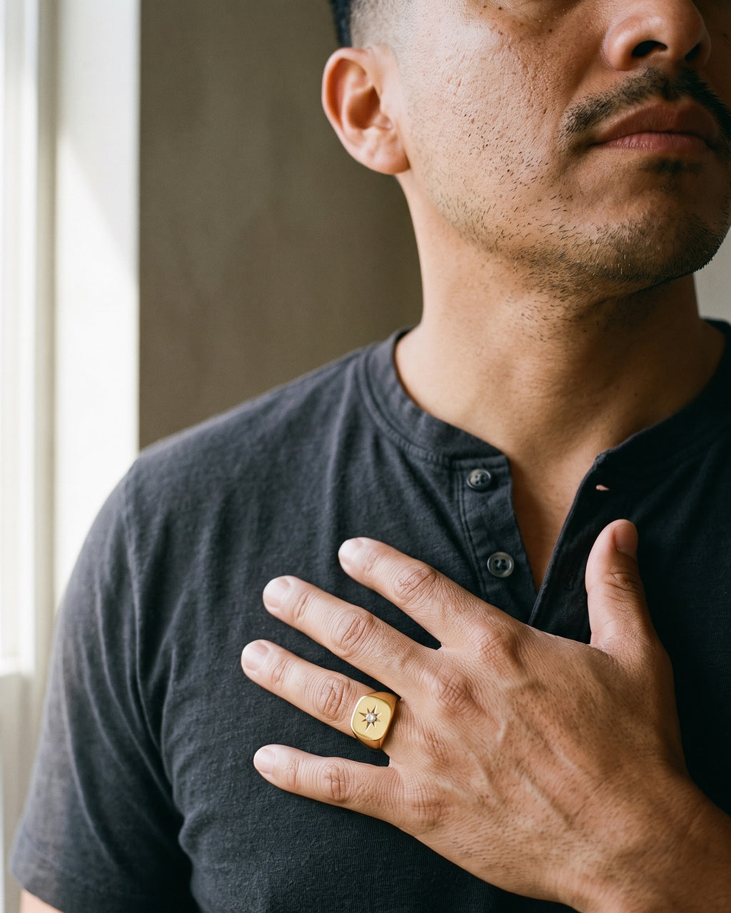 Atlas star signet ring in gold-tone stainless steel worn on a man's hand, close-up