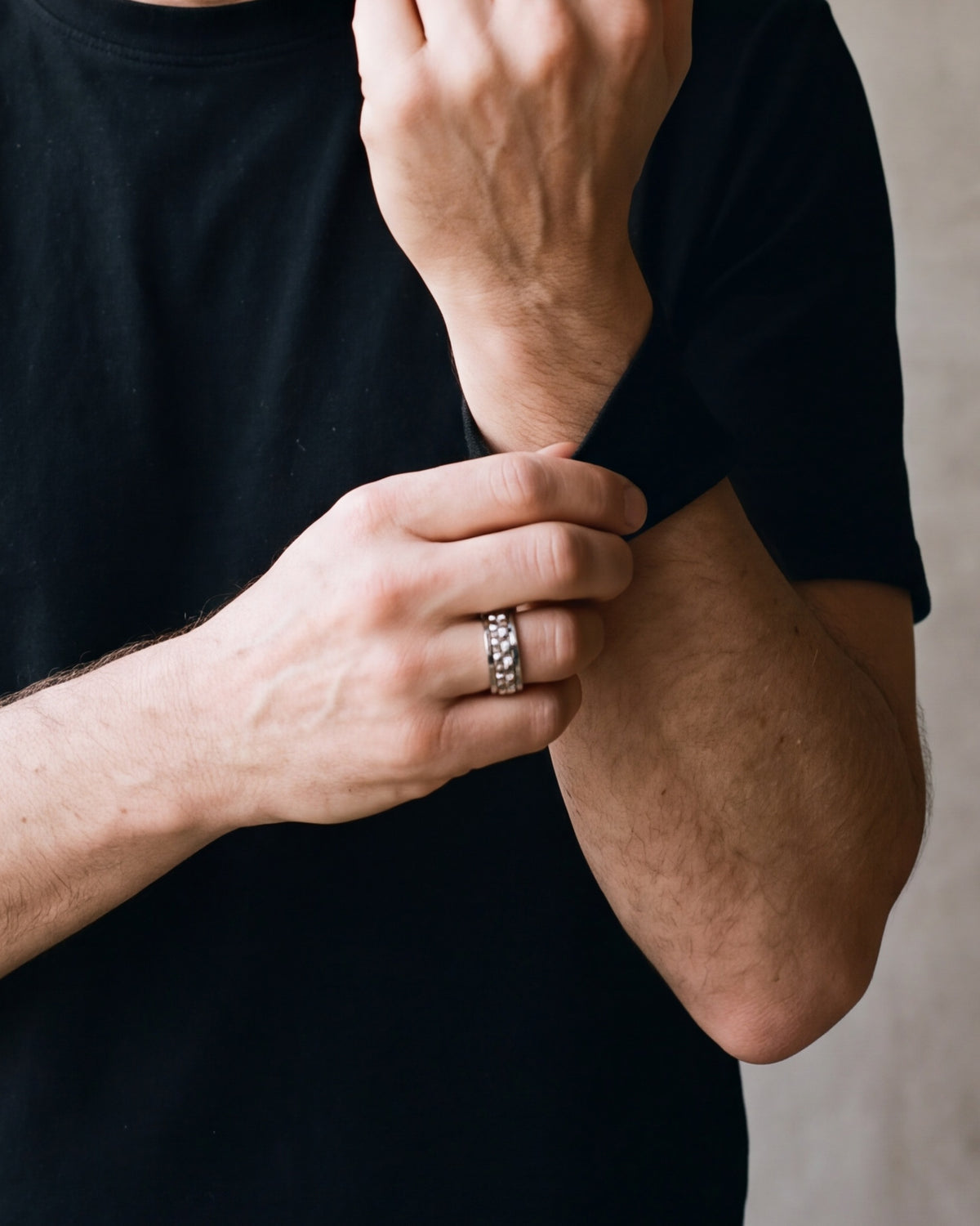 Close-up of the silver-tone Atlas textured spinner ring worn by a man, shown at true size