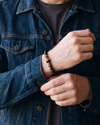 Close-up of the 8 mm Atlas tiger eye beads on a man's wrist at true size