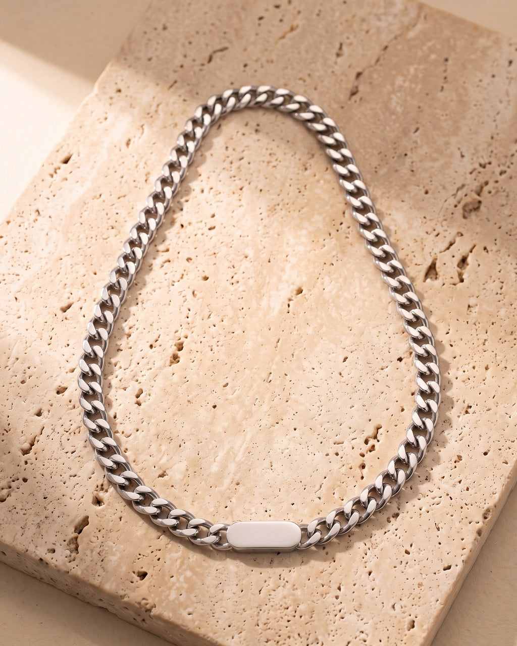 The whole silver-tone Atlas Cuban bar chain on warm stone, blank bar link and lobster clasp