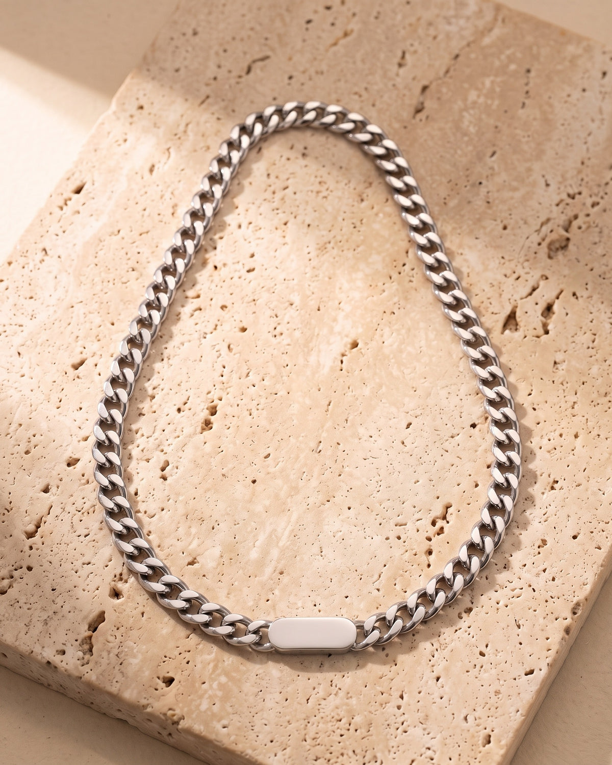 The whole silver-tone Atlas Cuban bar chain on warm stone, blank bar link and lobster clasp