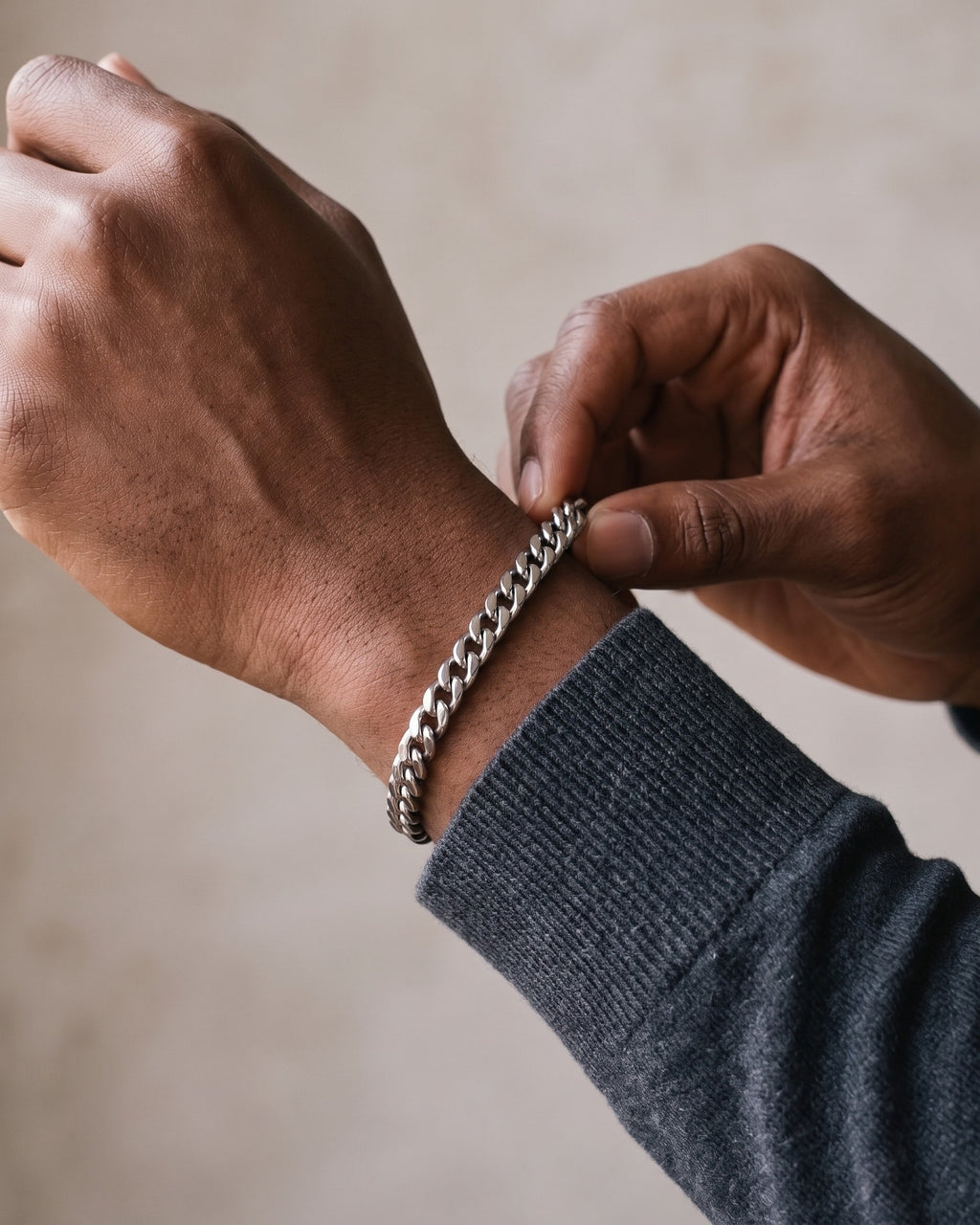 Hand adjusting the Atlas Titanium Steel Cuban Link Bracelet on the wrist