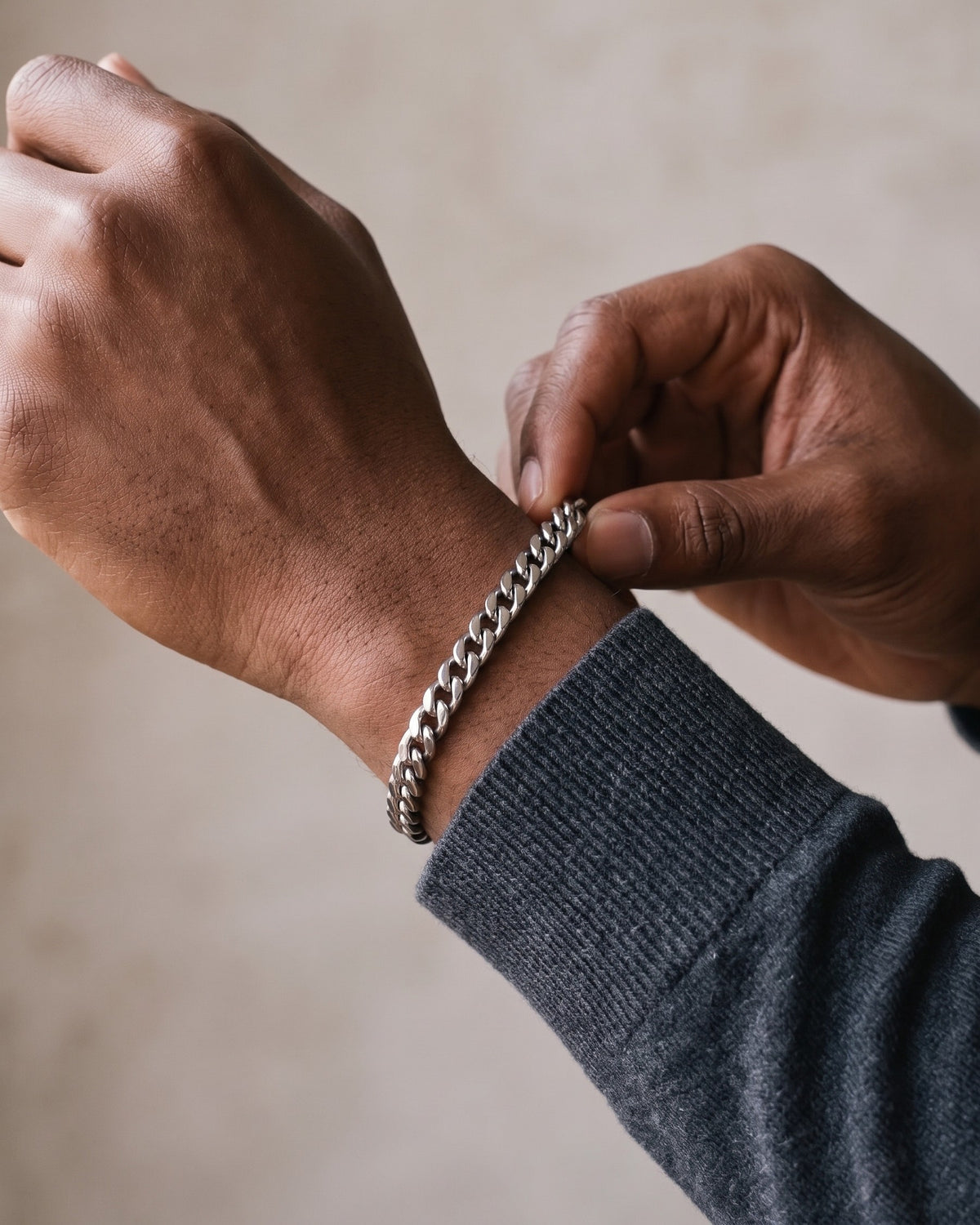 Hand adjusting the Atlas Titanium Steel Cuban Link Bracelet on the wrist