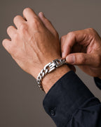 Hand adjusting the Atlas Titanium Steel Curb Link Bracelet on the wrist