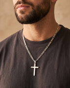 Close-up of the Atlas Figaro Chain Cross Necklace in Titanium Steel worn by a man, shown at true size