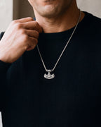 Close-up of the silver-tone Atlas Viking hammer pendant necklace worn, true size