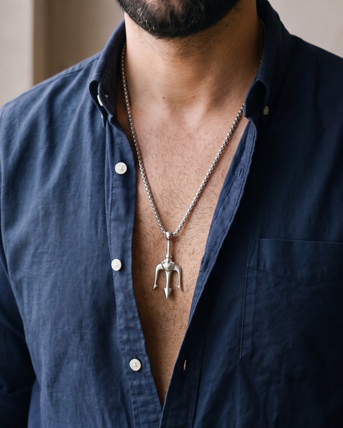 Close-up of the silver Atlas Trident Pendant Necklace in Titanium Steel worn by a man, shown at true size