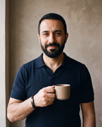 Second man in a navy fine-gauge knit polo with an open collar wearing the black Atlas twin wheat chain bracelet