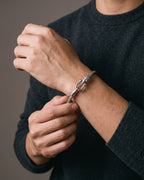 Hand adjusting the Atlas Twisted Cable Bangle in Stainless Steel on the wrist