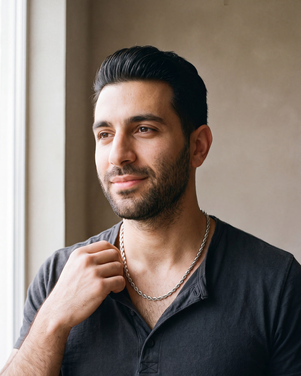 Man in a charcoal cotton henley t-shirt by a window wearing the silver Atlas Twisted Rope Chain