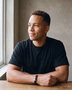 Second man in a plain heavyweight black cotton crew-neck t-shirt (thick wearing the gold-tone Atlas two-tone bar braided leather bracelet
