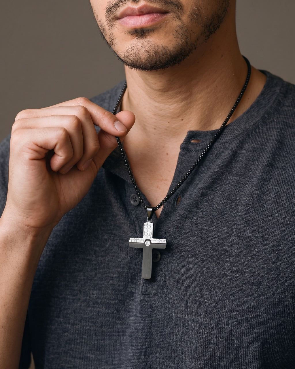 Hand lifting the Atlas Two-Tone Cross Necklace with CZ at the collarbone