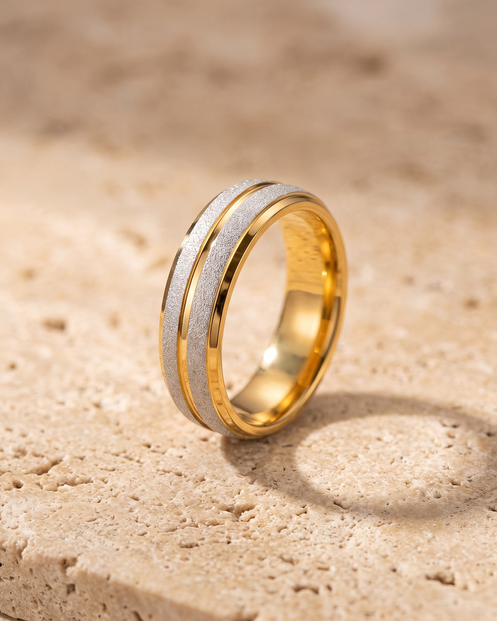 The whole plain Atlas two-tone frosted band lying on warm travertine stone