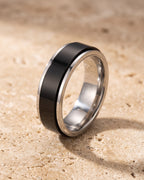 The whole silver-tone Atlas two-tone spinner ring lying on warm travertine stone