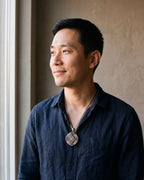 Man in a dark navy linen shirt by a window wearing the silver Atlas Vegvisir Viking Compass Pendant Necklace