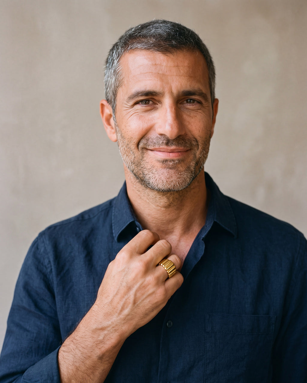 Second man in a dark navy linen shirt wearing the gold-tone Atlas vertical stripe cuff ring
