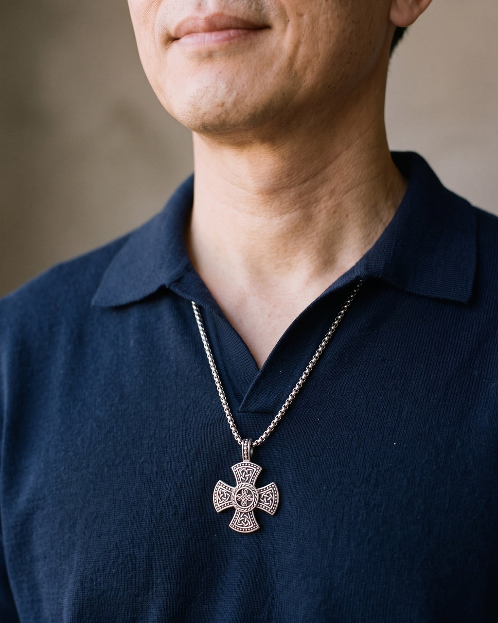Close-up of the Atlas Viking knotwork cross pendant necklace in silver-tone steel worn on the chest at true size