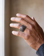 Close-up of the antiqued silver-tone Atlas Viking knotwork ring worn by a man, shown at true size