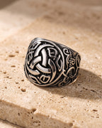 The whole antiqued silver-tone Atlas Viking knotwork ring laid on warm stone