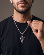 Hand lifting the Atlas Viking Valknut Arrow Necklace at the collarbone
