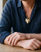 Close-up of the gold-tone Atlas viking wolf pendant necklace worn at true size