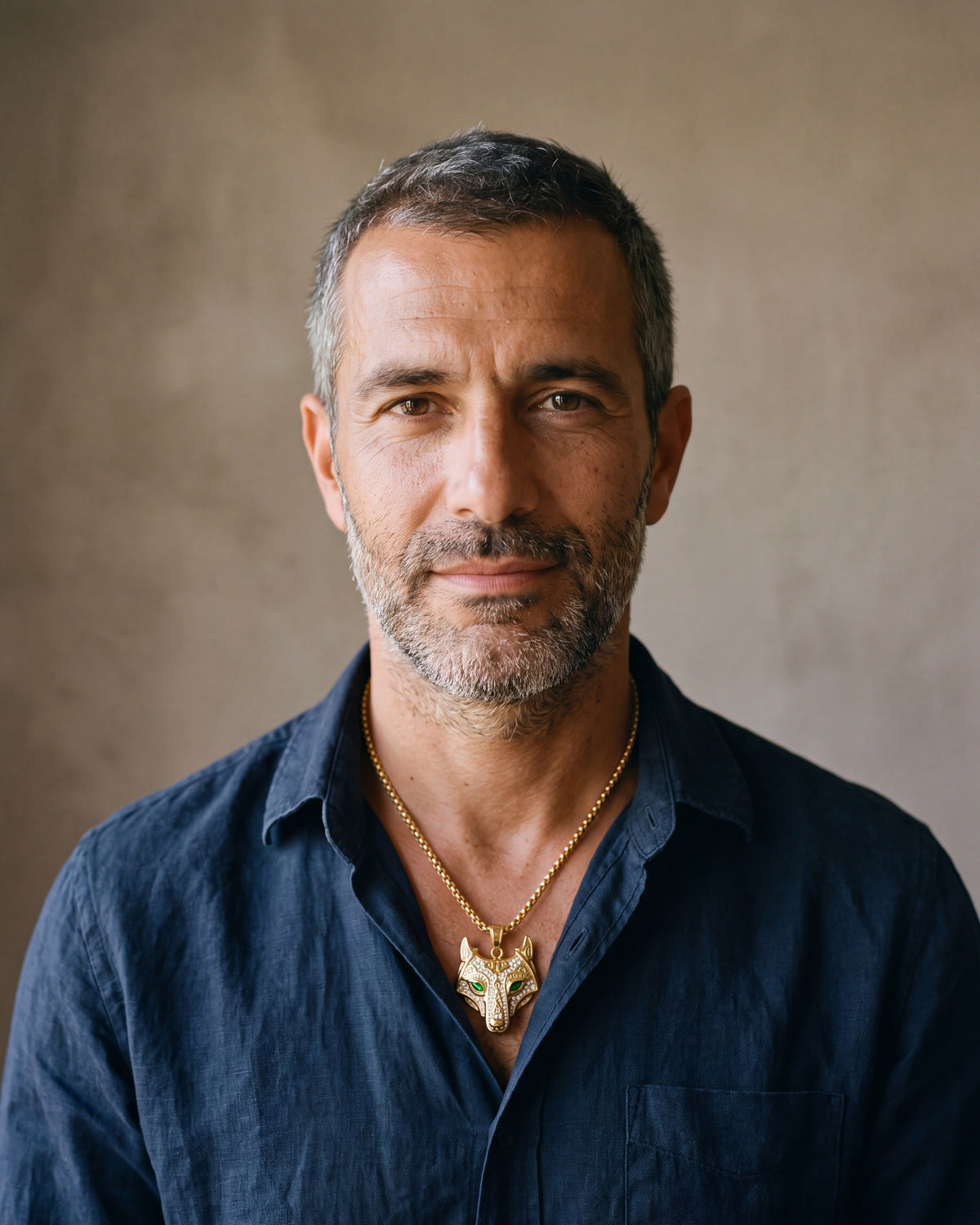 Second man in a dark navy linen shirt wearing the gold-tone Atlas viking wolf pendant necklace