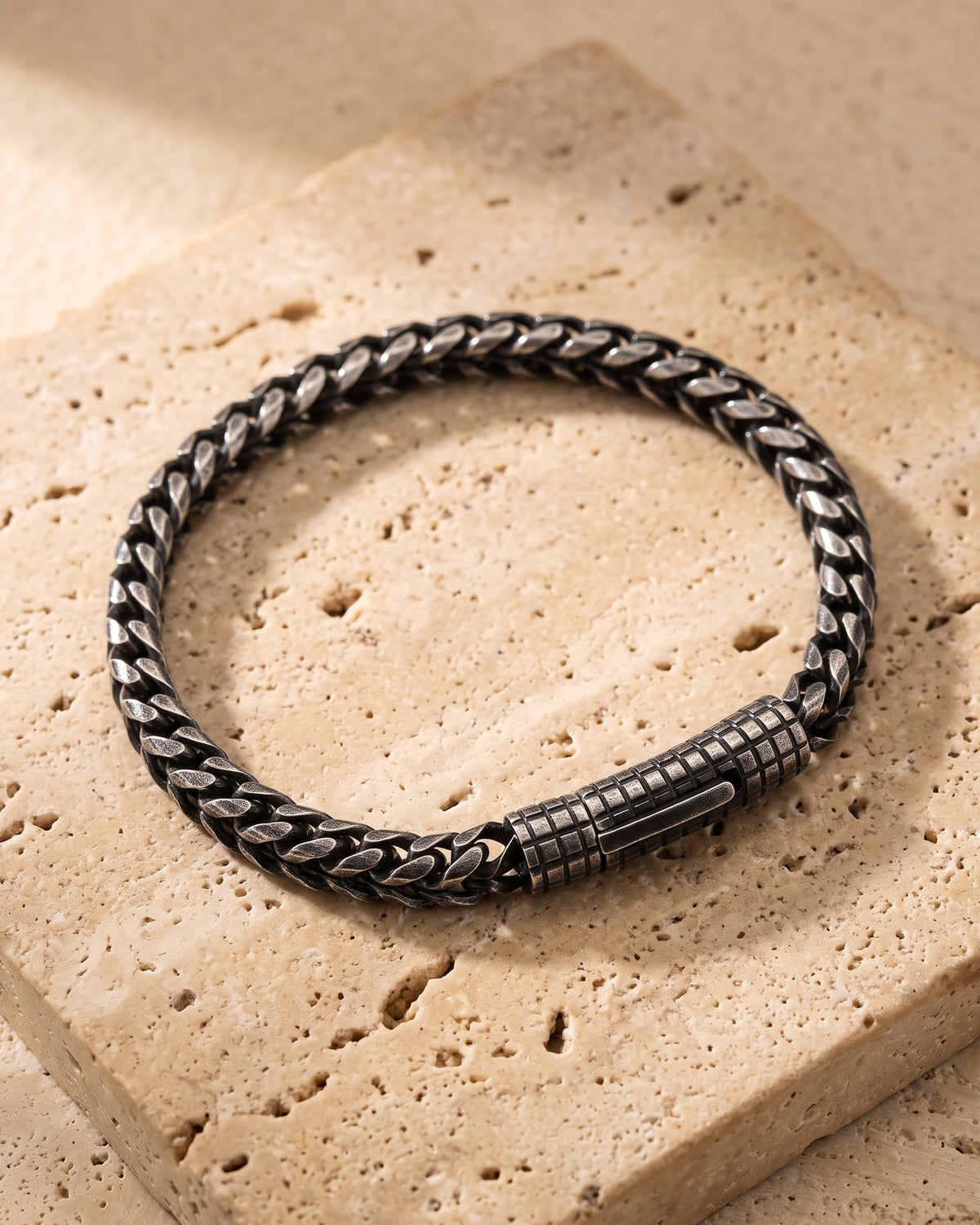 The whole antiqued black Atlas vintage wheat chain bracelet laid on warm stone