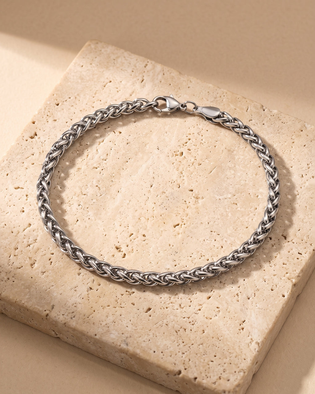 Atlas wheat chain bracelet closed on warm stone