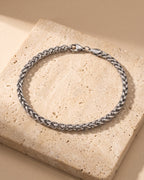 Atlas wheat chain bracelet closed on warm stone