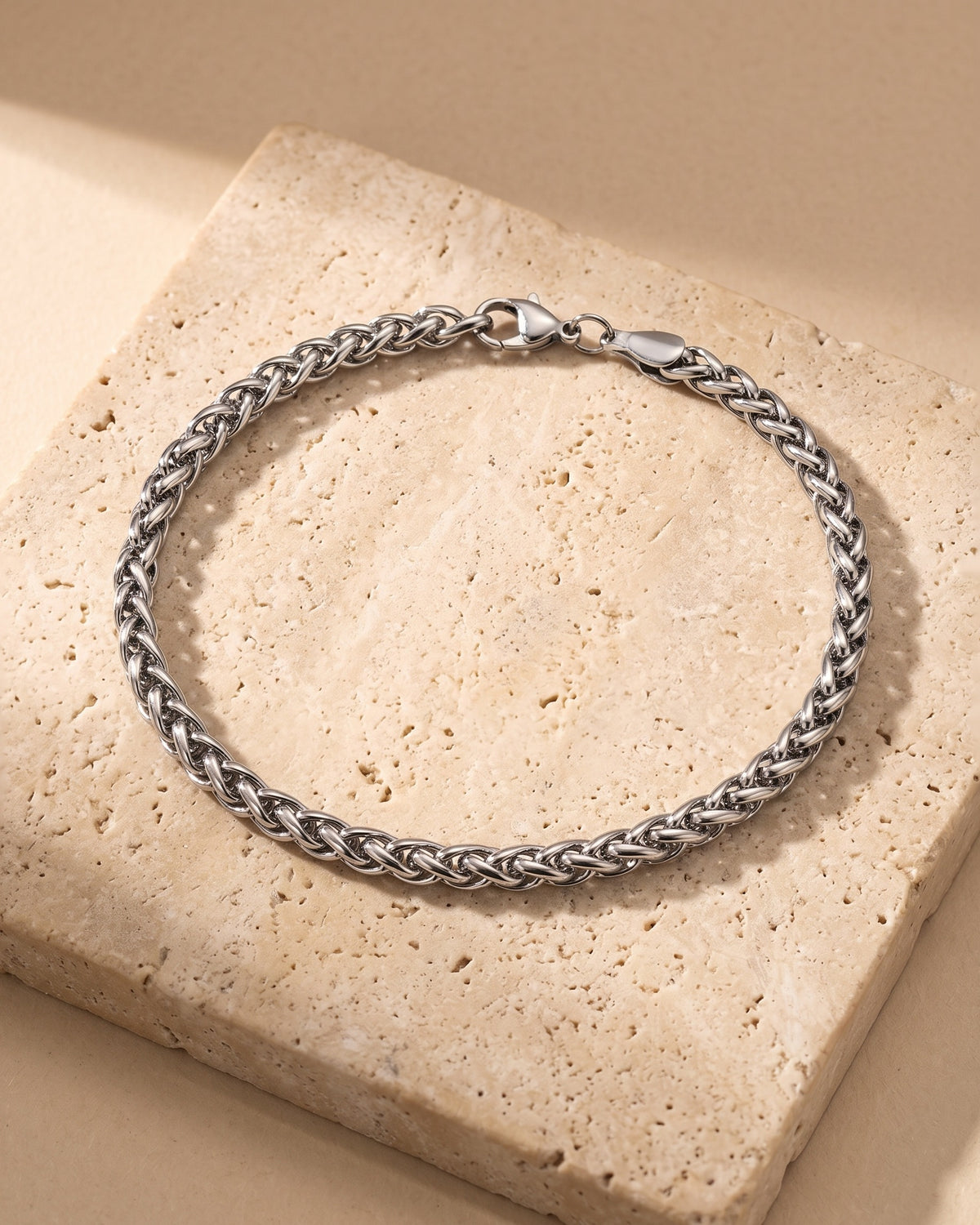 Atlas wheat chain bracelet closed on warm stone