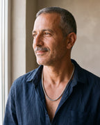Man in a navy linen shirt by a window wearing the 5 mm silver Atlas wheat chain