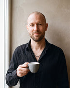 Man in a black shirt by a window wearing the Atlas wheat chain in silver-tone steel