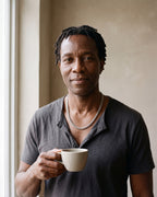 Man in a charcoal cotton henley t-shirt by a window wearing the silver Atlas wheat chain