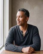 Man in a charcoal henley seated by a window, wearing the silver Atlas wheat chain
