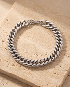 The whole silver Atlas wide Cuban link bracelet laid on warm stone