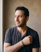 Man in a charcoal henley by a window wearing the silver Atlas wide Cuban link bracelet