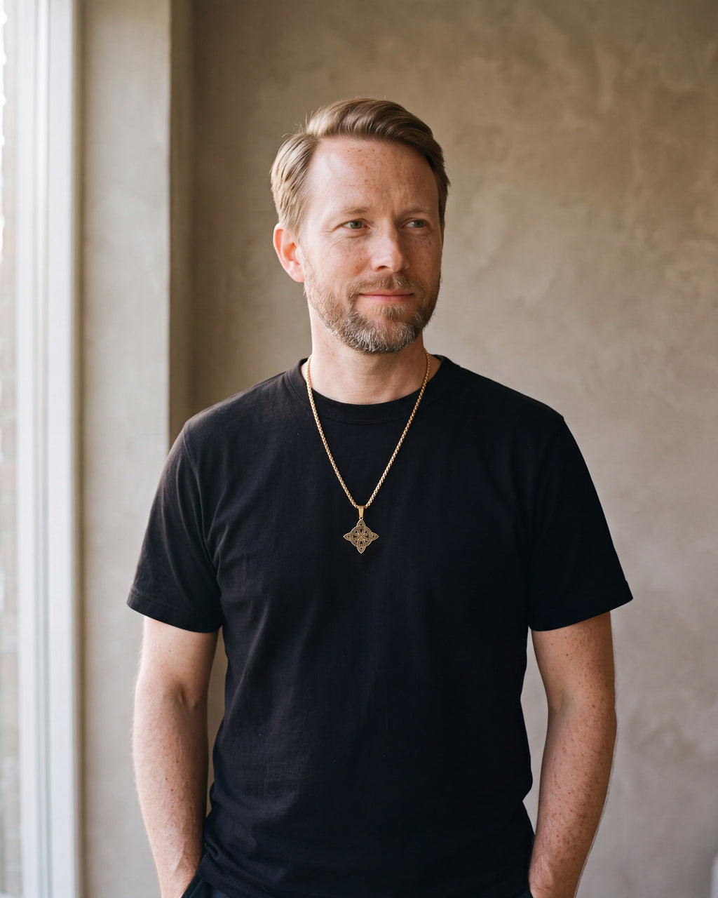 Man in a black t-shirt wearing the gold-tone Atlas Celtic witch's knot pendant necklace