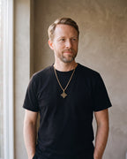 Man in a black t-shirt wearing the gold-tone Atlas Celtic witch's knot pendant necklace