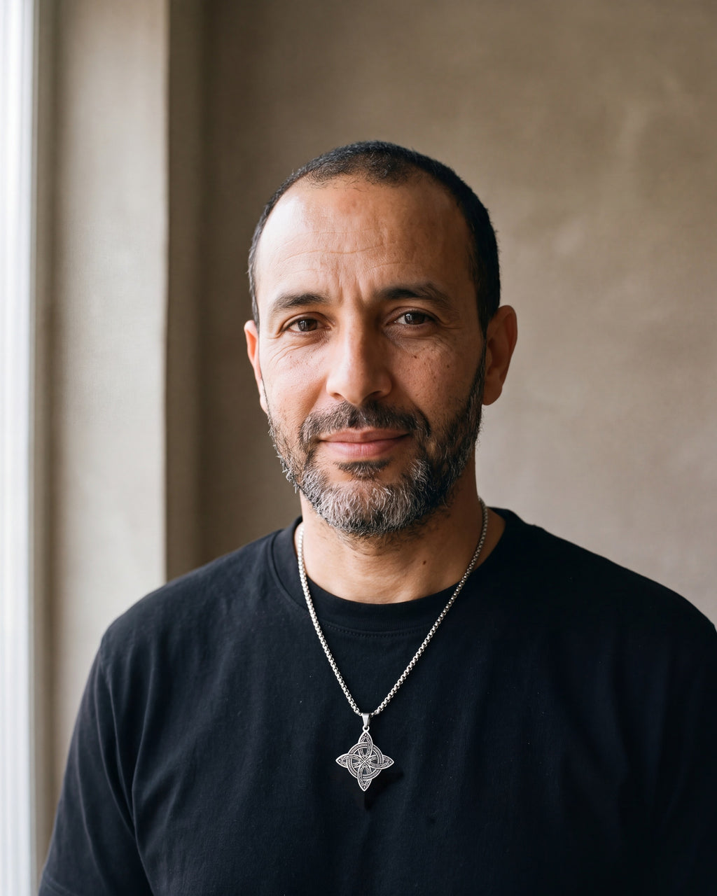 Man in a black t-shirt wearing the silver-tone Atlas Celtic witch's knot pendant necklace