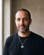 Man in a black t-shirt wearing the silver-tone Atlas Celtic witch's knot pendant necklace