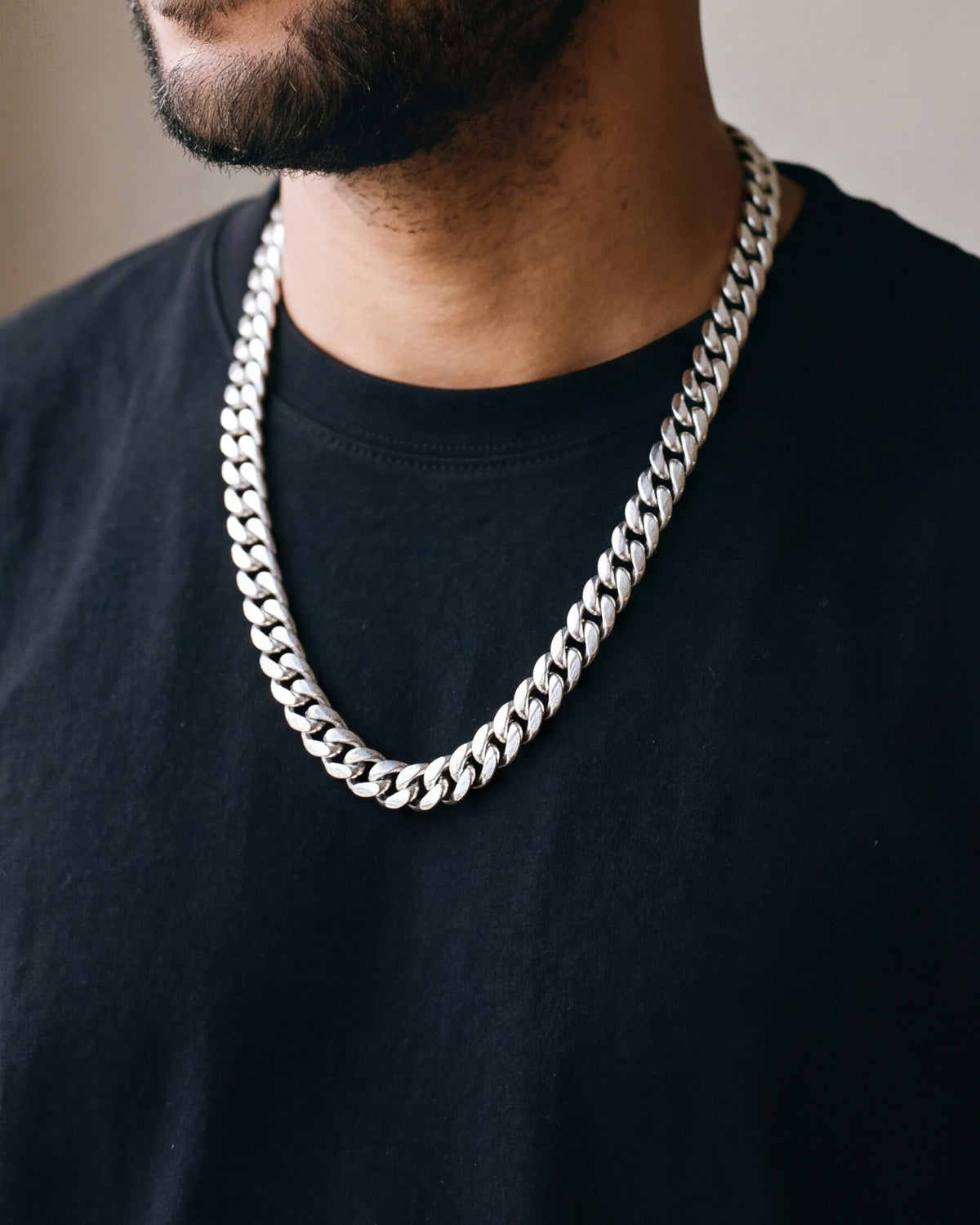 Close-up of the Atlas Cuban chain with zircon cross clasp in silver-tone steel, worn at true size