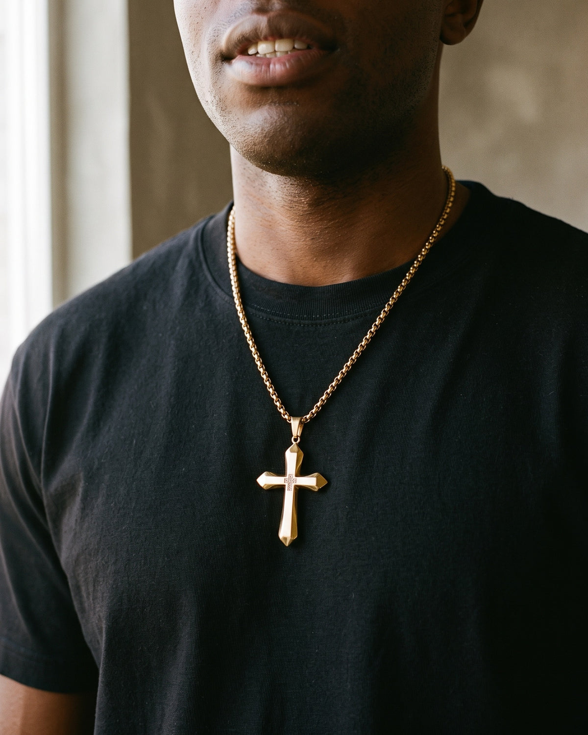 Atlas zircon cross pendant necklace in gold-tone titanium steel worn on the chest, close-up