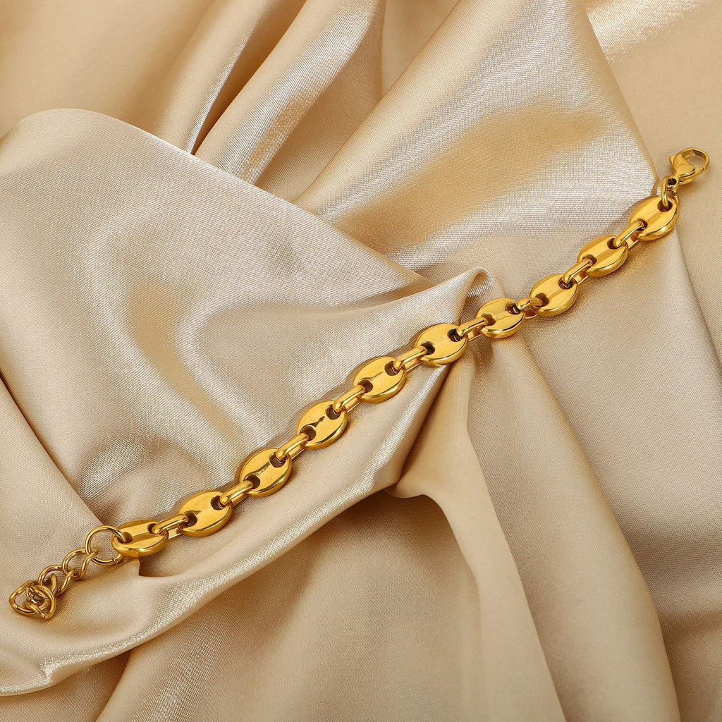 Gold-Tone Coffee Bean Link Bracelet on a light gold fabric background