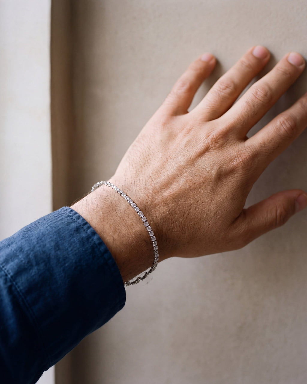 Close-up of the silver Atlas iced tennis bracelet worn by a man, true size